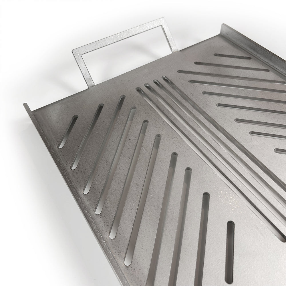 
                  
                    Close up of a stainless steel grill plate showing grill slats for cooking on an open fire pit.
                  
                