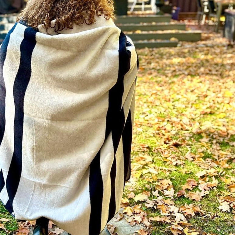 
                  
                    Woman wearing black and white striped cotton blanket outdoors on fall.
                  
                