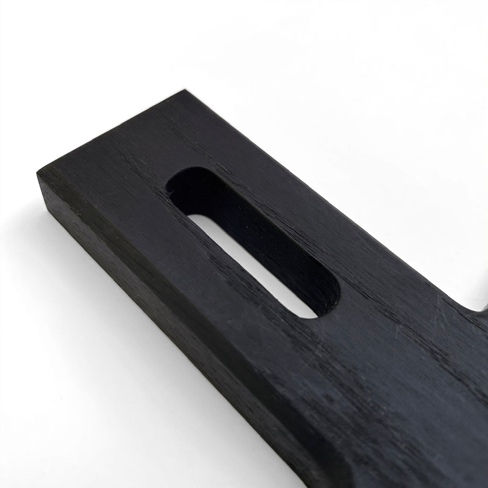 
                  
                    Extra close up shot of the angular handle of the Paddle serving board in blackened oak.
                  
                