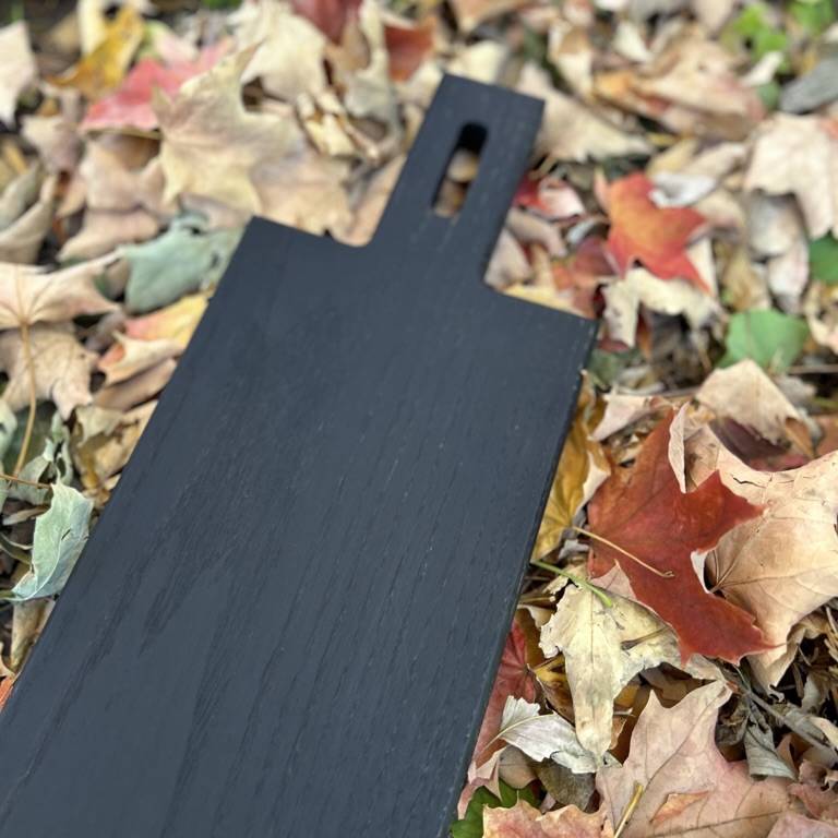 
                  
                    Close up shot  of serving board sitting on autumnal leaves.
                  
                