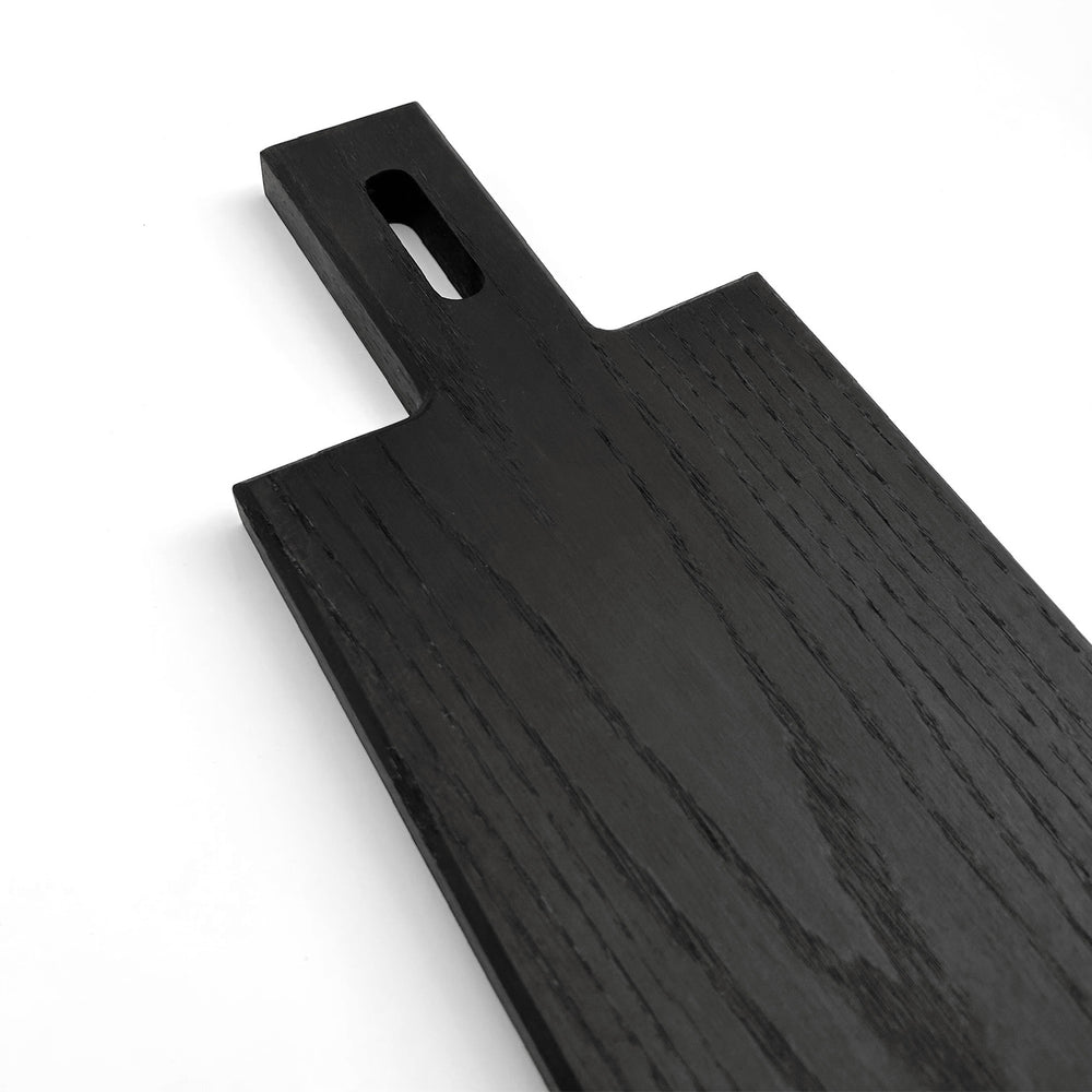 
                  
                    Extra close up shot of the angular handle of the Paddle serving board in blackened oak.
                  
                