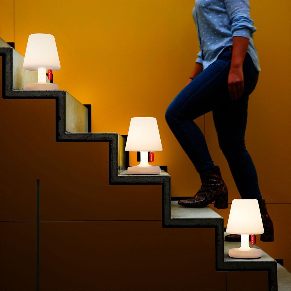 Shot of lady going upstairs with three Edison the petit lamps on each step. 